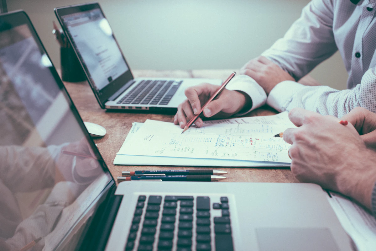 A planning session with documents and laptops on a desk