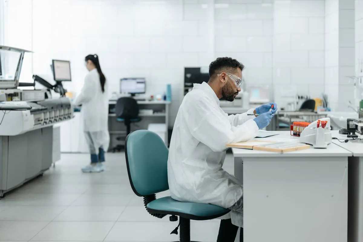 A laboratory scientist examining a sample under a microscope