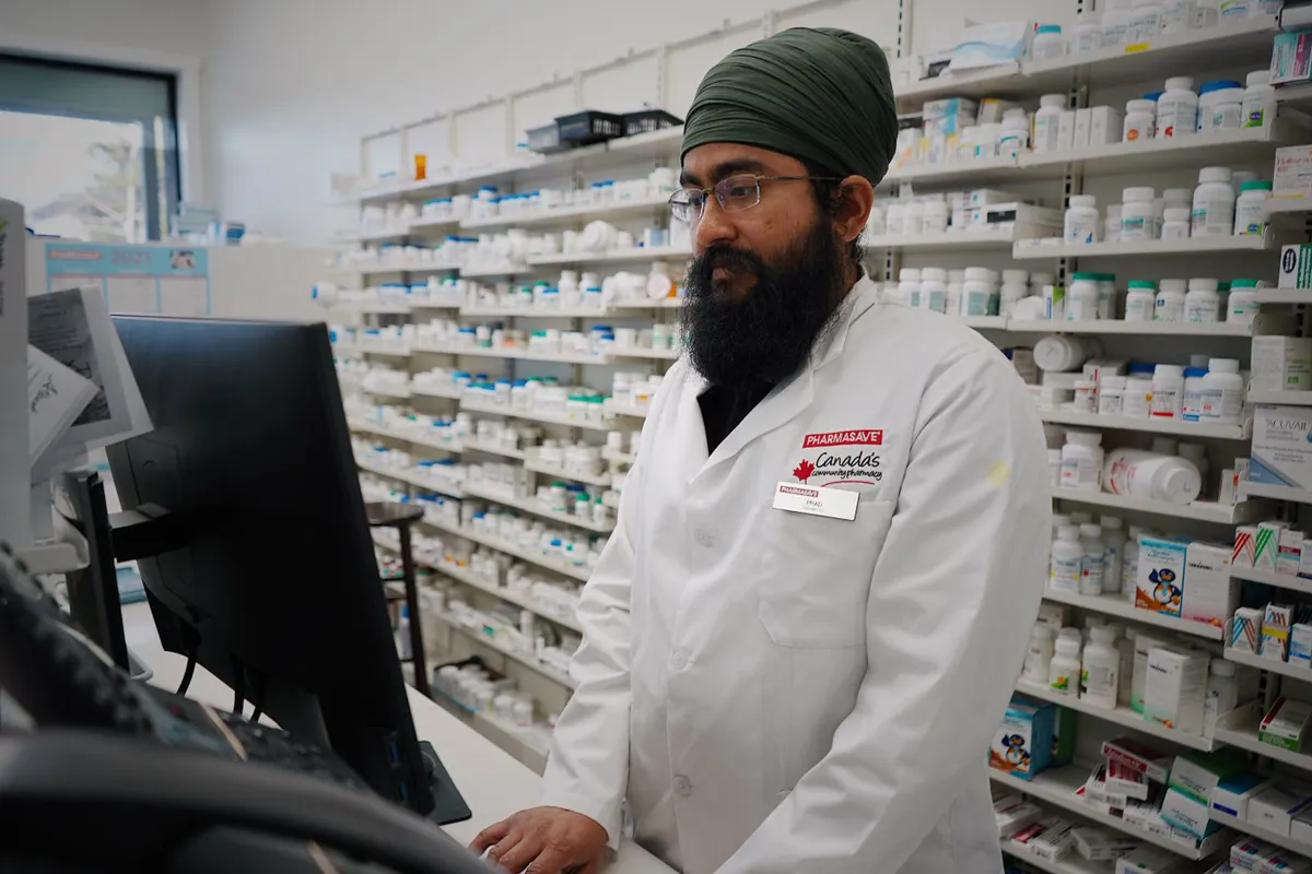 A pharmacist working at a pharmacy dispensing counter